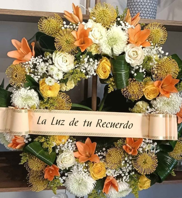 Corona Tonos Cálidos corona fúnebre luminosa de liliums amarillos. un homenaje especial con servicio de floristería urgente en el tablero.